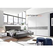 Camera matrimoniale con letto in ecopelle cemento, armadio con fascia beton e comodini bianchi opachi