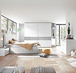 Camera matrimoniale con letto in ecopelle bianco, armadio con fascia beton e comodini bianchi opachi