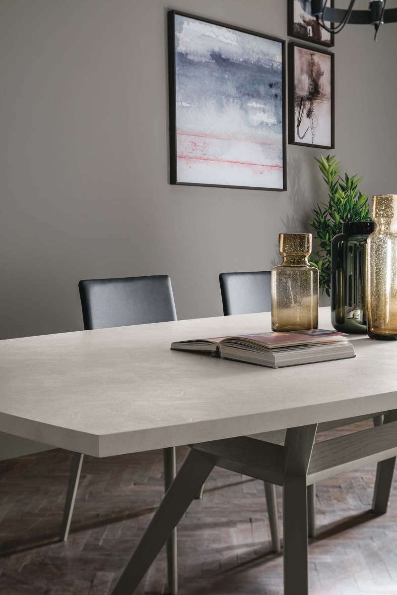 Tavolo di prestigio con piano materico cemento chiaro