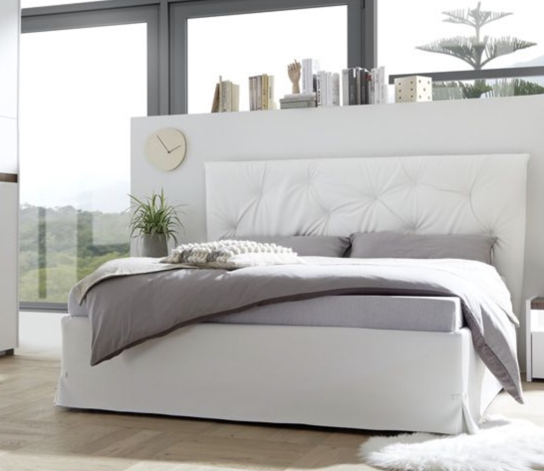 Camera matrimoniale con letto in ecopelle tabacco, armadio con anta noce dark e comodini bianchi opachi