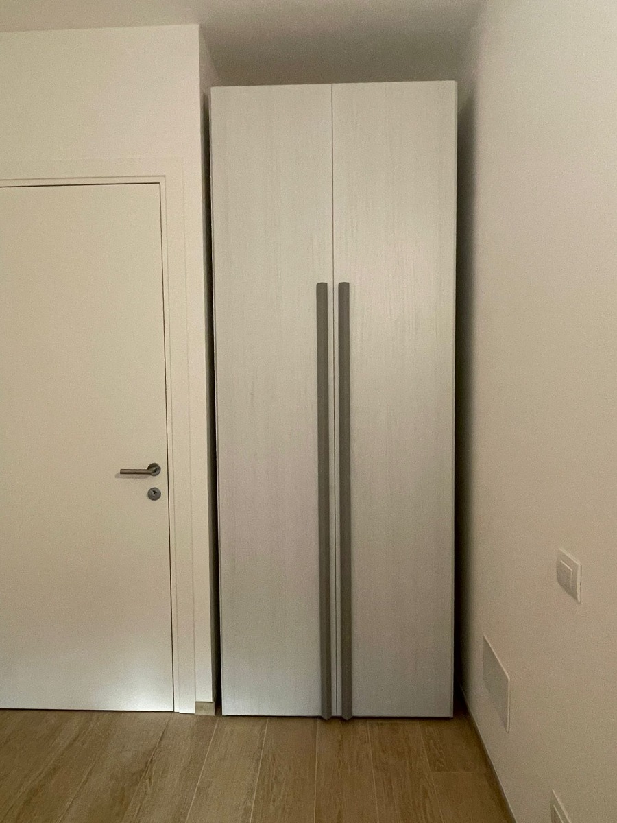 Funzionale Armadio moderno con 2 ante battenti, finitura Bianco altea con maniglie grigie